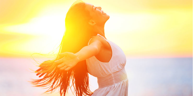 Bild von glücklicher Frau im Sonnenuntergang mit langen Haaren